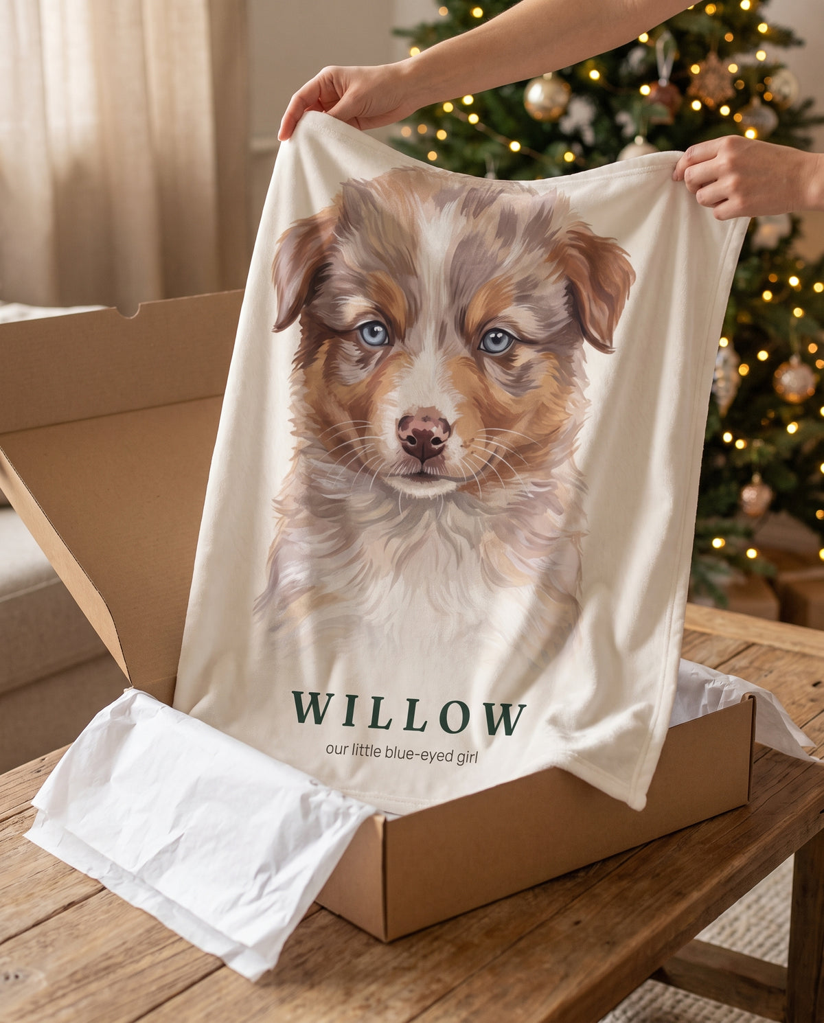 Willow’s personalized puppy portrait throw being lifted from a gift box beside a Christmas tree.